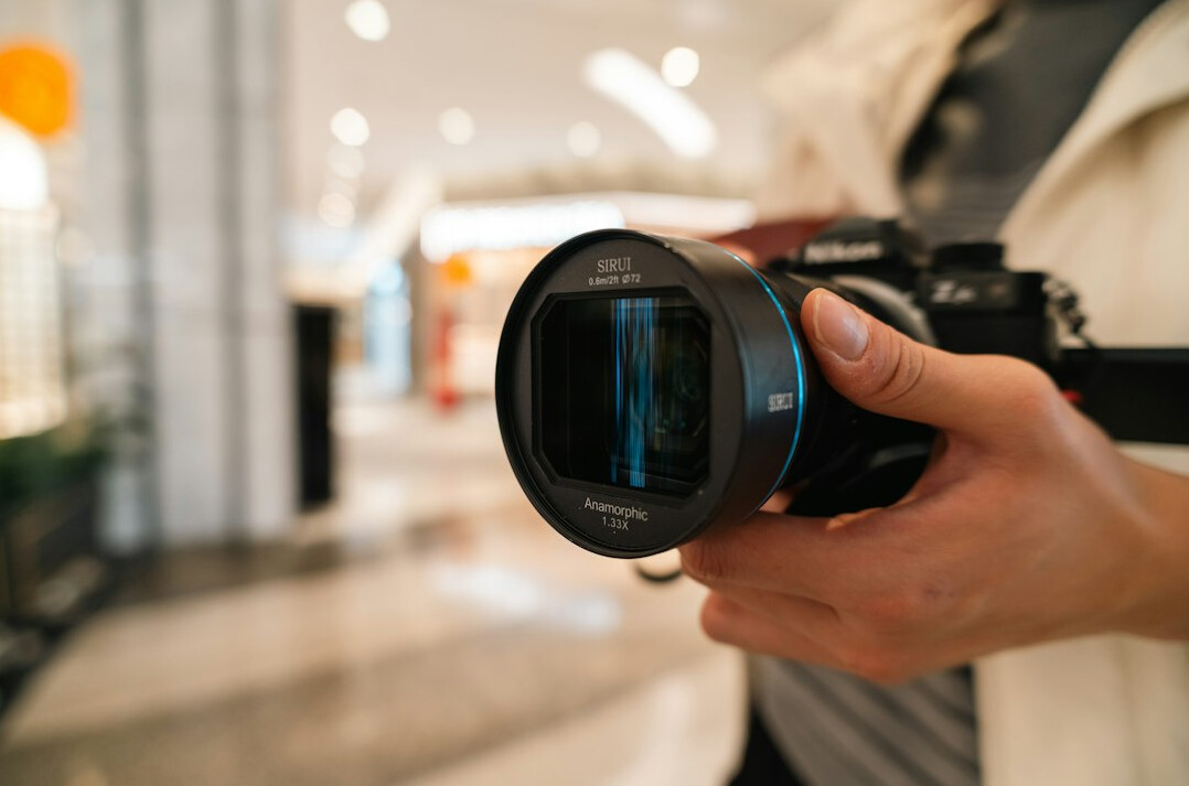 Camera operator filming a presenter on a news studio set