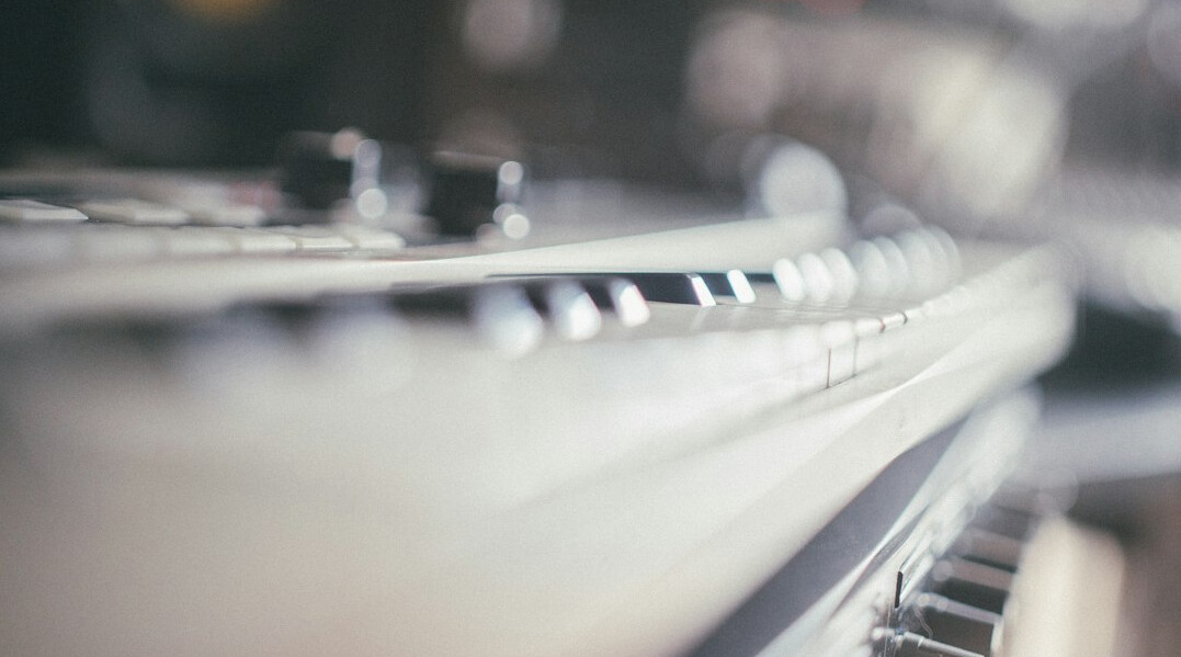 Close up of an audio mixing console with sliders and knobs