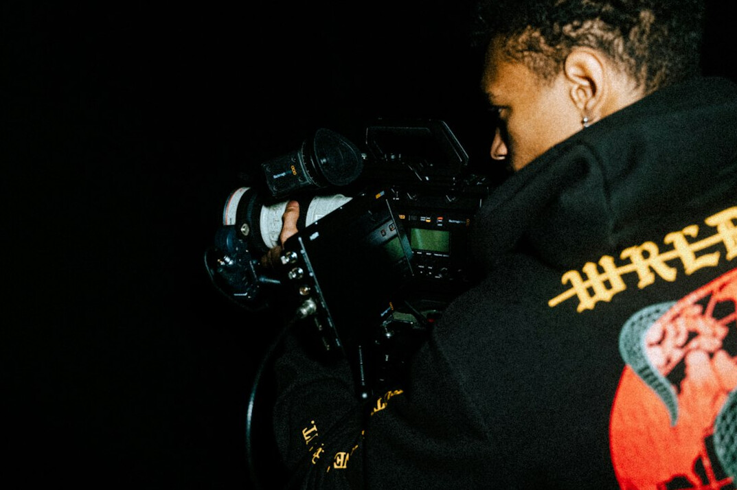 Camera operator behind a broadcast camera on a studio set